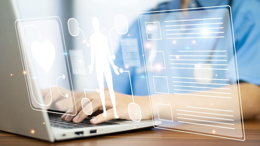 Medical professional works on a laptop with digital health data.